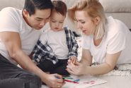 Loving family creating art together, fostering play and connection indoors.