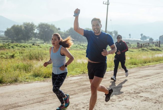 Group of people enjoying a morning run on a rural trail, embracing fitness and vitality.