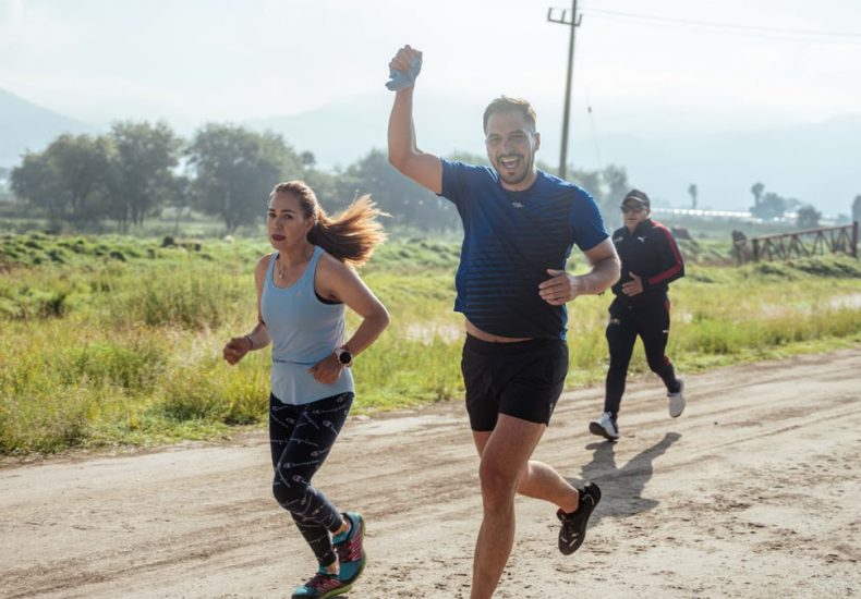 Group of people enjoying a morning run on a rural trail, embracing fitness and vitality.